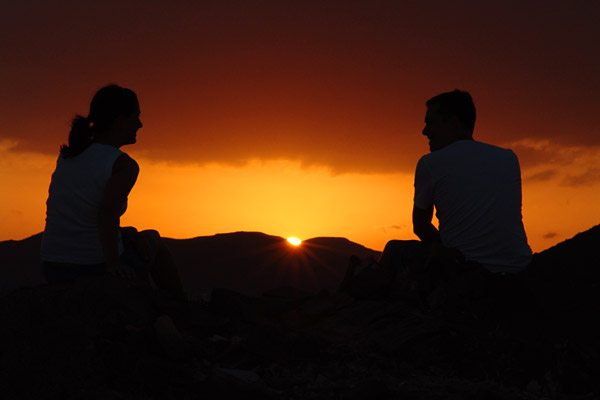 Bilquis & Christian sitzen vor dem Sonnenuntergang